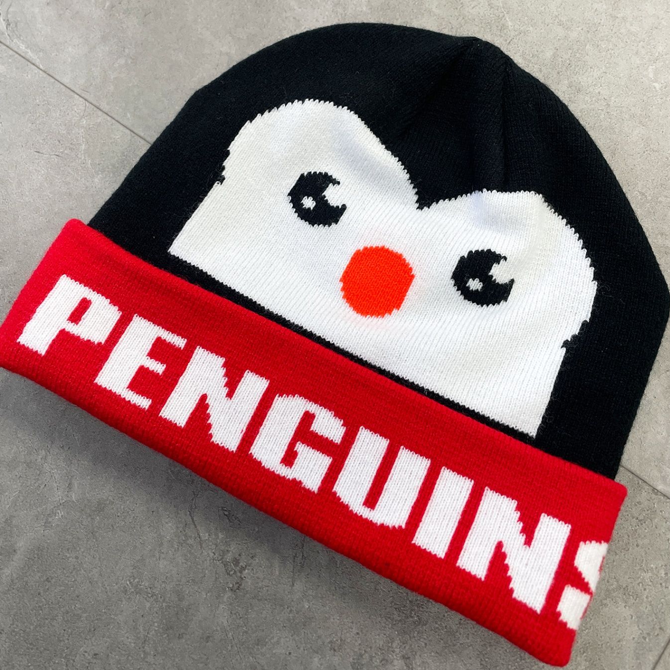 An image of an all over print toque with a penguin design