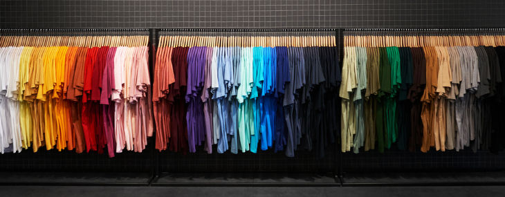 An image of a variety of t-shirts in different colours hanging on a rack.