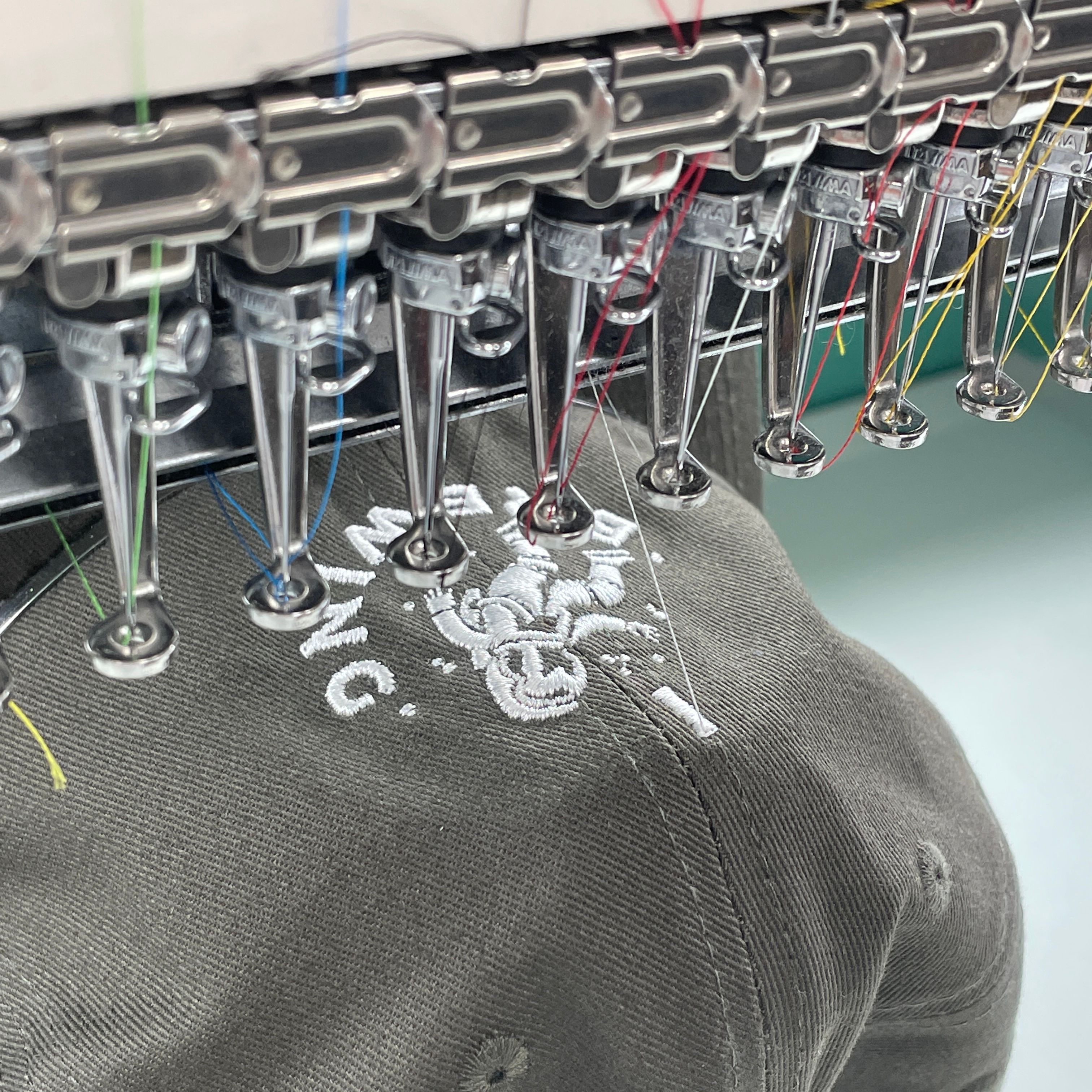 A close-up of a hat being embroidered