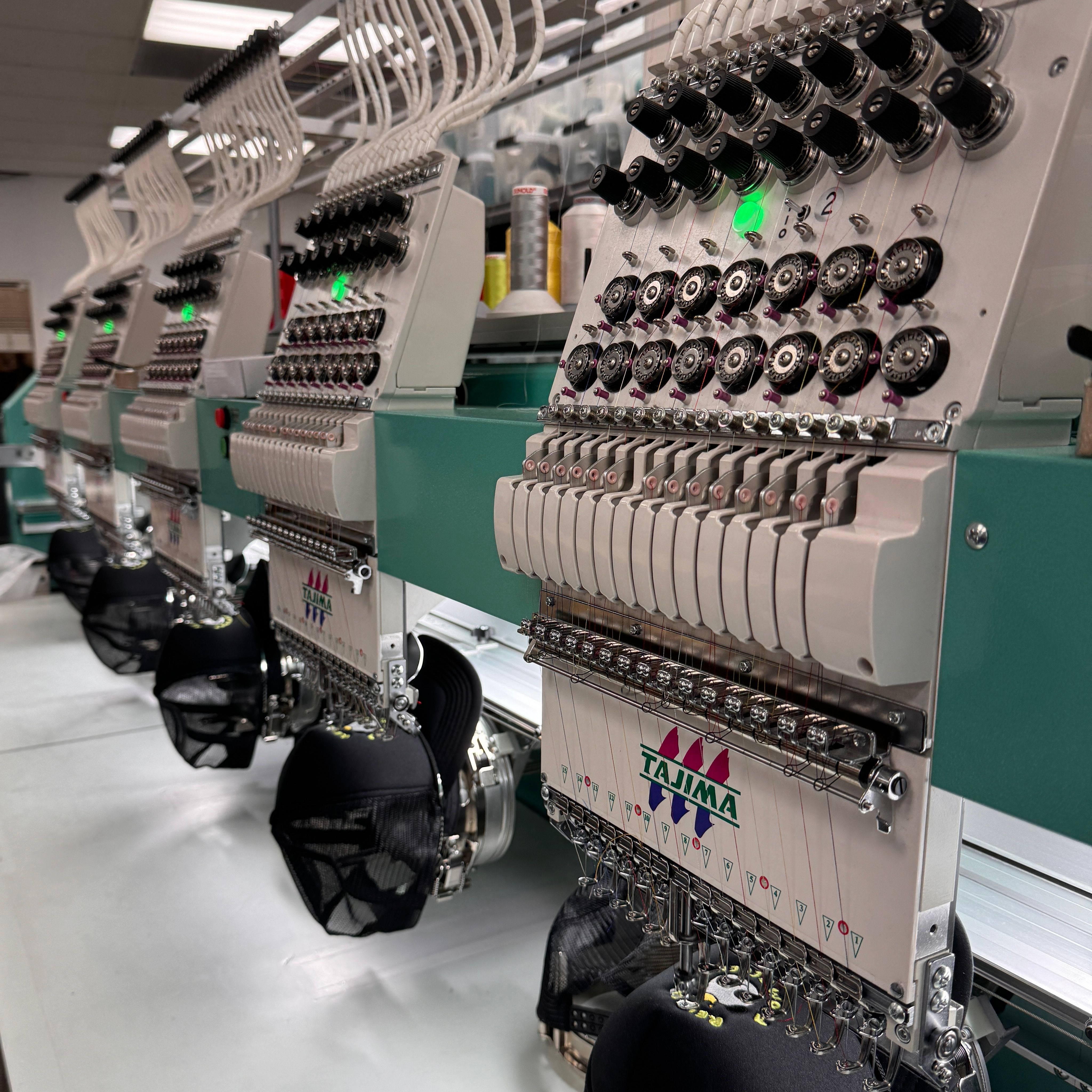 An image of our Tajima embroidery machines, while they are embroidering a hat.