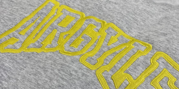An image of a close up flat embroidery design printed on the back of sweatpants.