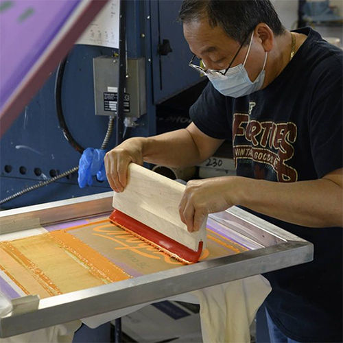 An image of one of our screen printings, printing on the manual screen printing press.