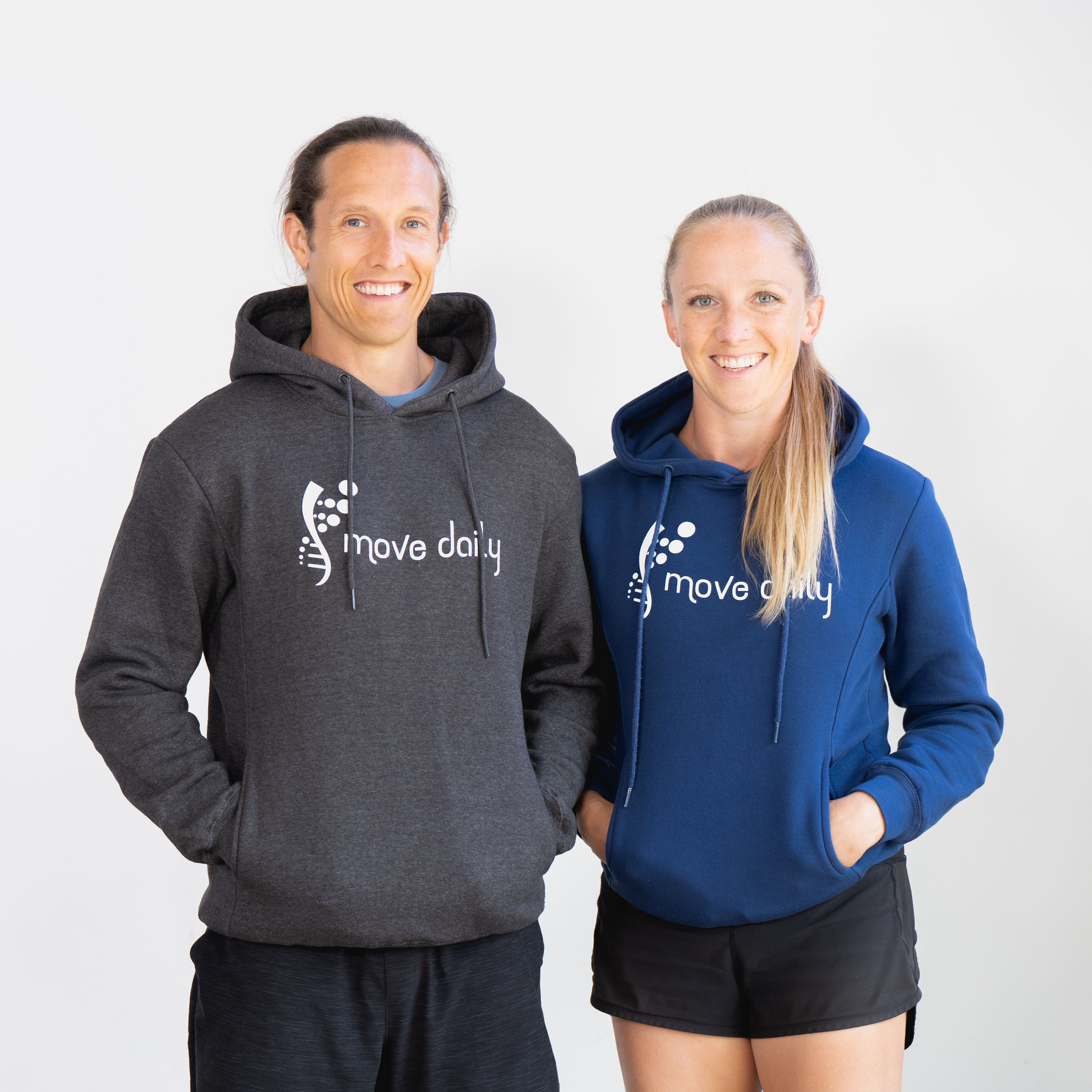 Two people wearing hoodies we screen printed with a front design for Move Daily.