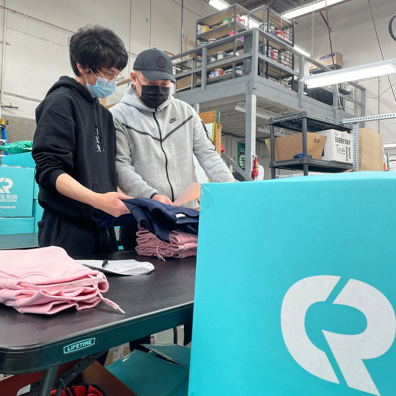 Team member in the warehouse carefully reviewing each product to ensure order accuracy and print quality.