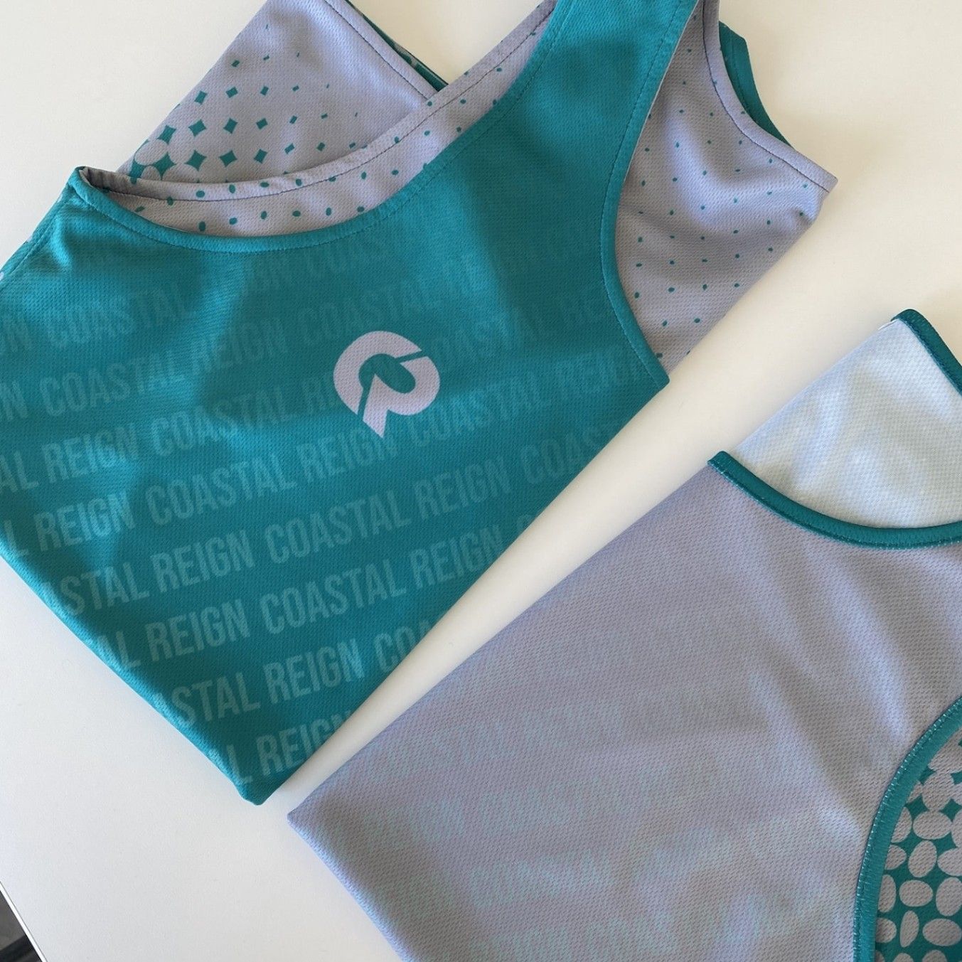 A sublimated tank top printed with a Coastal Reign design