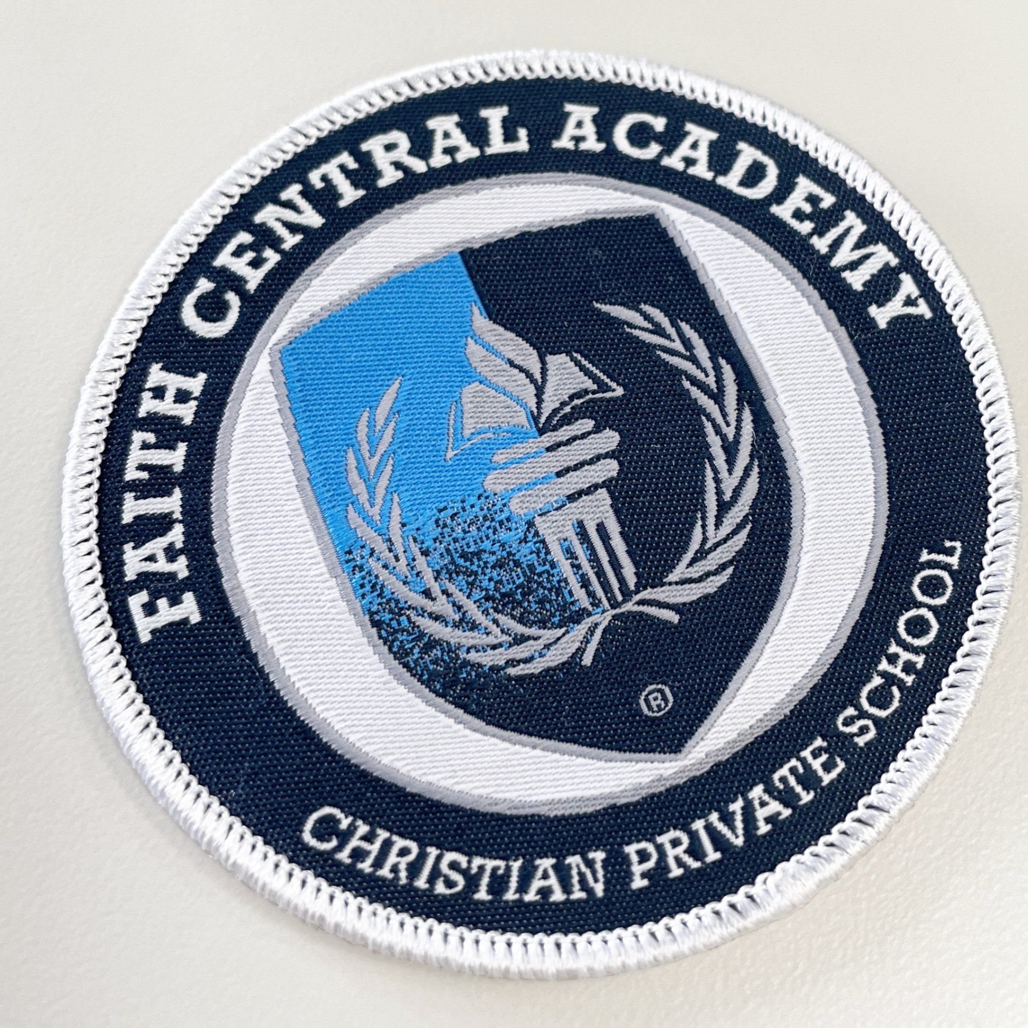 Custom circle shaped woven patch made for faith central academy. This woven patch has a lot of intricate details.